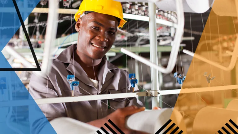 Man smiling and working in a manufacturing setting. Overlayed with Make UK branding