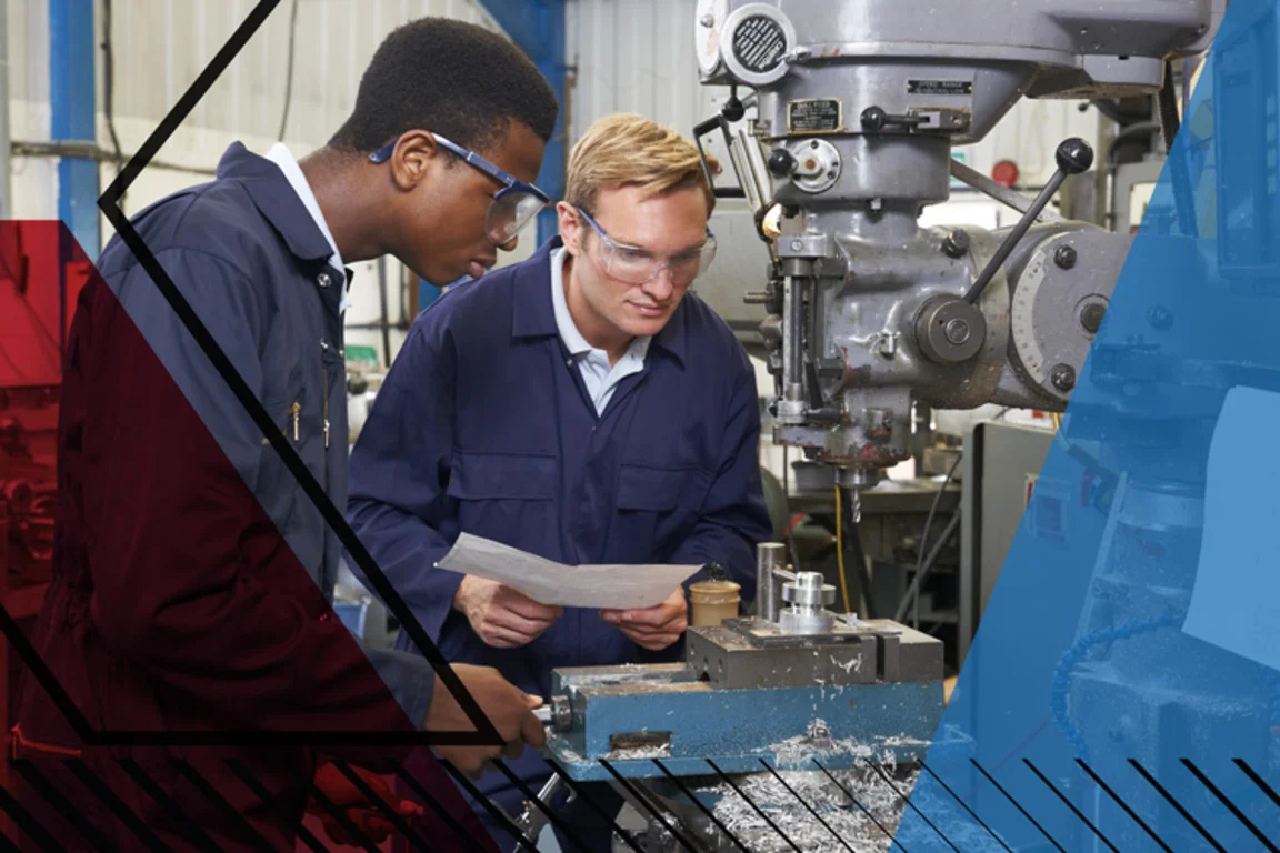 Young man using drilling machinery in a factory setting whilst another looks on. Make UK branded