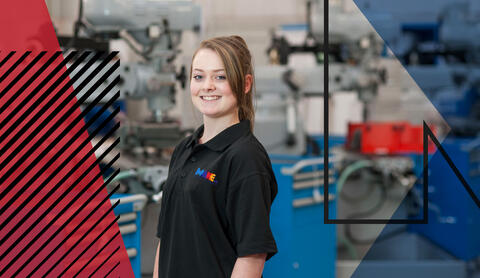 Image of woman wearing Make UK polo top in a factory setting. Make UK branded