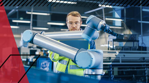 Man looking at robotic arm used in assembly line in a factory setting. Make UK branded